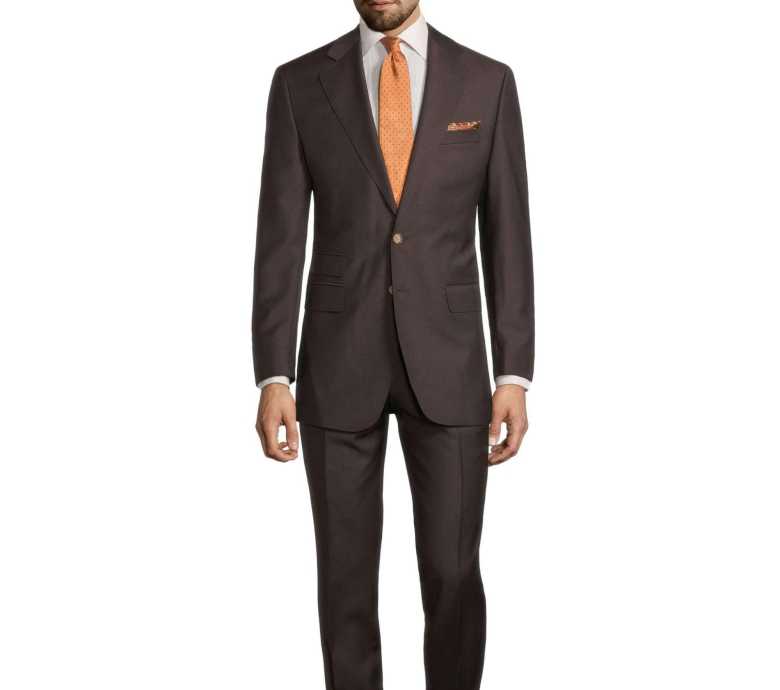 brown single breasted suit paired with an orange tie by Oliver Wicks