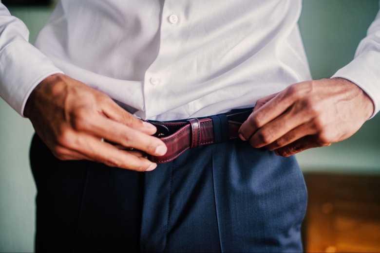 Close up Image of Man Putting on a Belt