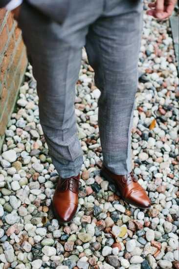 Close up of Light Grey suit Pants with Brown Shoes on Rocks