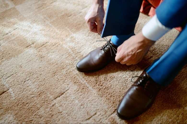 Man Tieing his Brown Formal Shoes