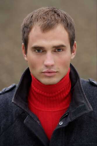 Man Wearing a Red Turtle Neck and Black Jacket